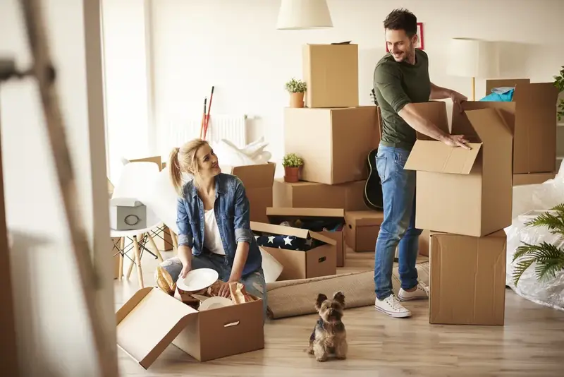 A couple unpacking moving boxes in their new apartment